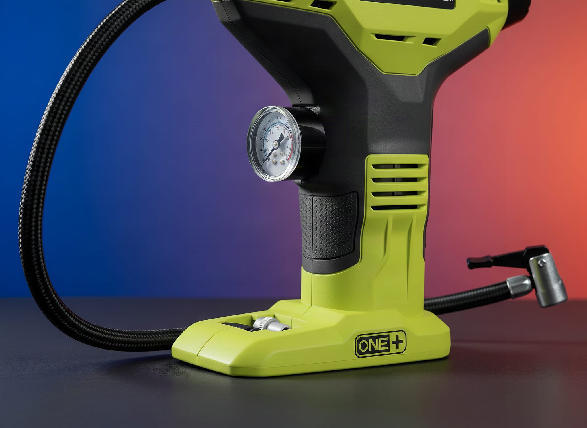 Close-up of the Ryobi R18PI-0 inflator nozzle and pressure gauge with shallow focus against a dark background